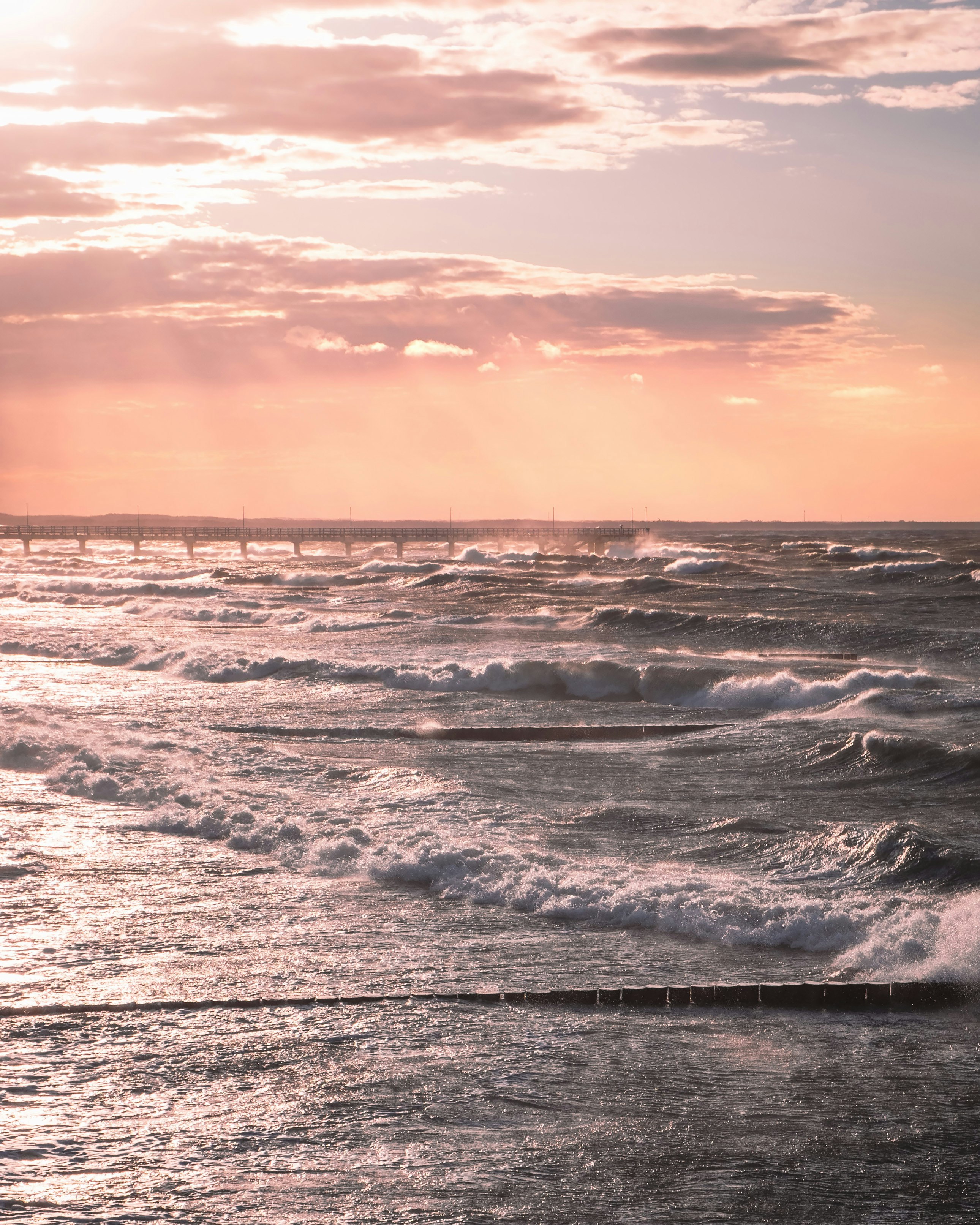 sea waves crashing on shore during sunset